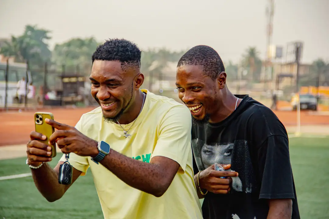 Two friends laughing at something on a phone